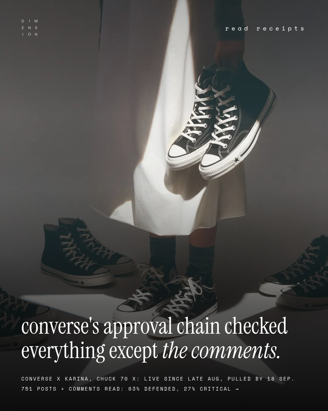 A person in a white dress holds a pair of black Converse Chuck 70 X high-tops above more pairs scattered on a studio floor, from the pulled Karina campaign